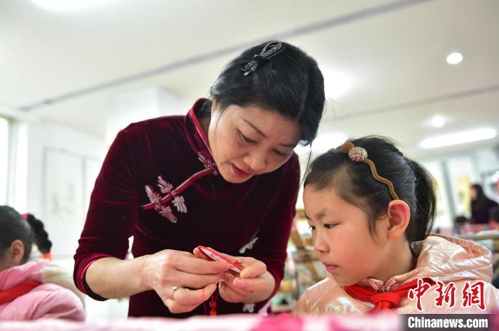 江西省級(jí)非遺豫章繡傳承人手把手指導(dǎo)小學(xué)生繡制2022年北京冬奧會(huì)吉祥物“冰墩墩”形象?！∮髟屏?攝
