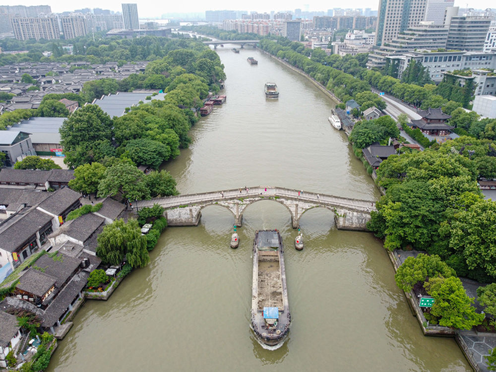 5月27日，一艘貨船駛過京杭大運河南端標(biāo)志建筑杭州拱宸橋。(無人機照片)新華社記者江漢 攝