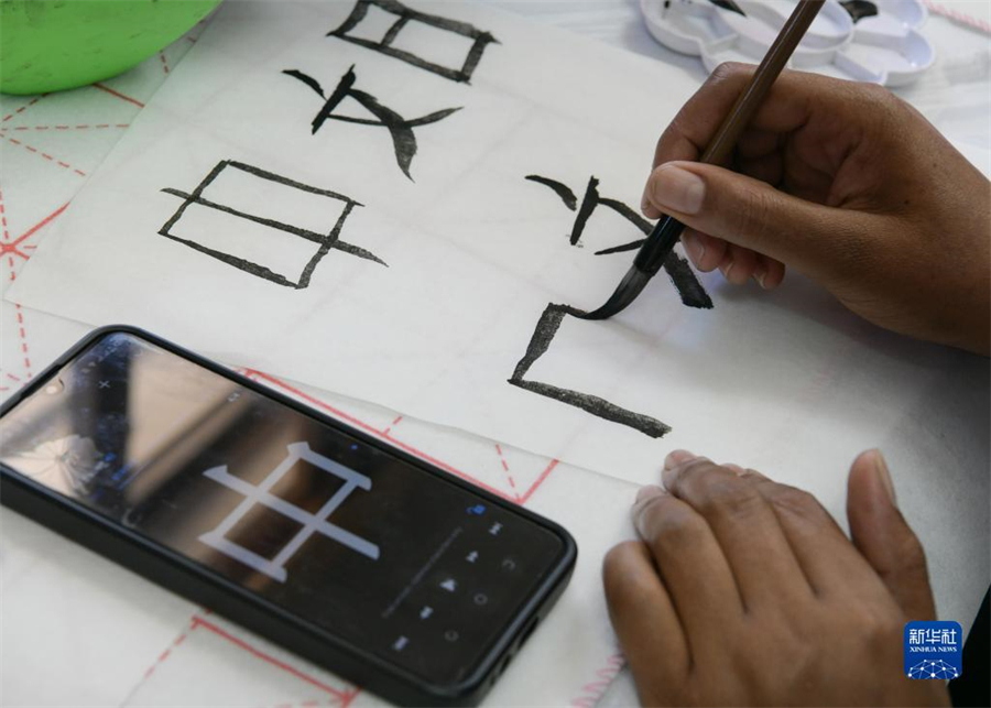 4月18日，肯尼亞學生在內羅畢大學孔子學院舉辦的活動上寫毛筆字?？夏醽唭攘_畢大學孔子學院18日舉辦“中文，增進文明對話”主題活動，慶祝即將到來的第14個聯(lián)合國中文日?？夏醽唽W生參與互動，進行書法、剪紙、唱中文歌等活動。新華社記者 韓旭 攝