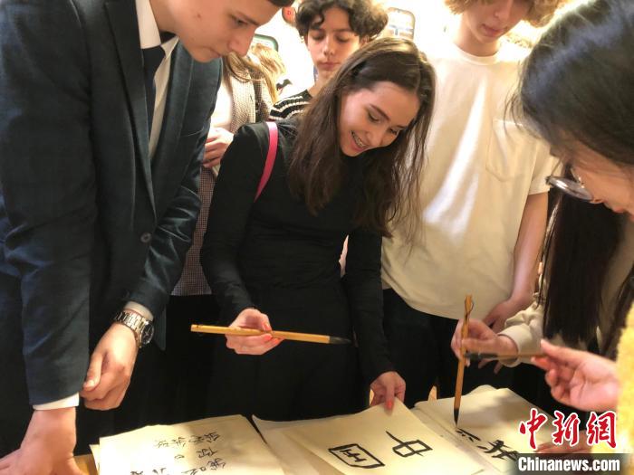 4月21日，莫斯科國立語言大學(xué)孔子學(xué)院附屬中學(xué)舉辦“國際中文日”活動(dòng)，學(xué)生們學(xué)寫漢字?！∧箍茋⒄Z言大學(xué)孔子學(xué)院 供圖