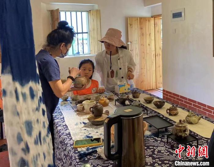 圖為：游客正在咨詢臺灣柴燒作品?！∪~秋云 攝