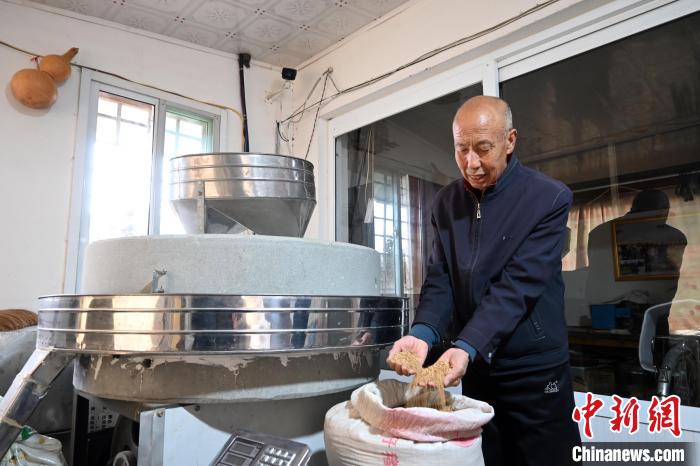 李家莊村民谷文朝重拾父輩的手藝，做起石磨面粉的營生?！〉杂鸺?攝