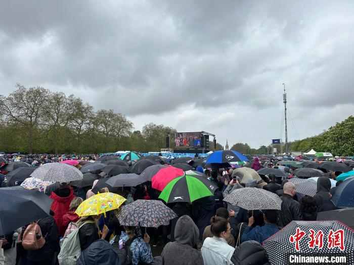 當(dāng)?shù)貢r(shí)間5月6日，英國國王查爾斯三世的加冕儀式舉行。民眾雨中觀看儀式。　歐陽開宇 攝