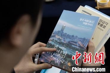 參展觀眾閱讀浙江文旅手冊?！《≌裾?攝