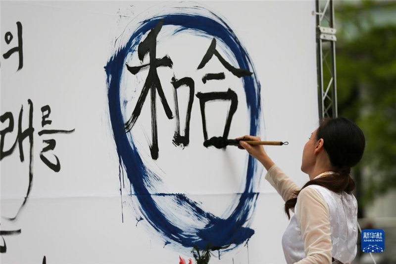 5月30日，在韓國首爾舉辦的“中日韓合作之日”慶?；顒又?，表演者進行中日韓精神——2023年度漢字“和合”書法表演。新華社記者 王益亮 攝