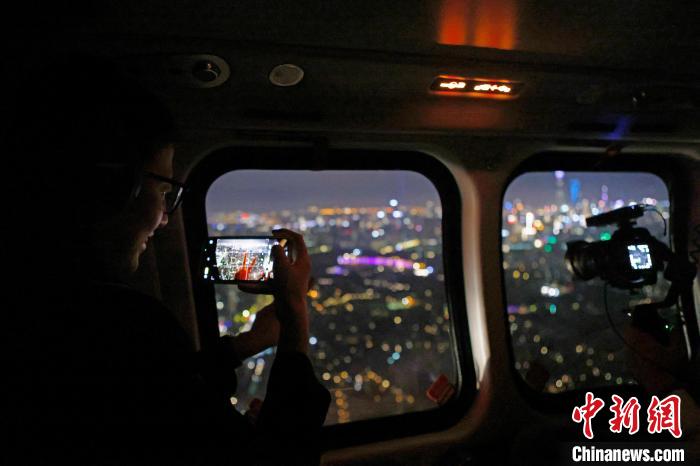 6月3日晚，游客乘坐上海新空直升機(jī)有限公司直升機(jī)開(kāi)啟鳥(niǎo)瞰黃浦江空中圓夢(mèng)之旅，并用手機(jī)拍攝城市夜景?！∫罅⑶?攝