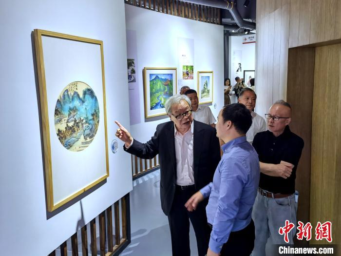 海峽兩岸藝術(shù)家畫展上，藝術(shù)家進行藝術(shù)交流?！「毒窜?攝