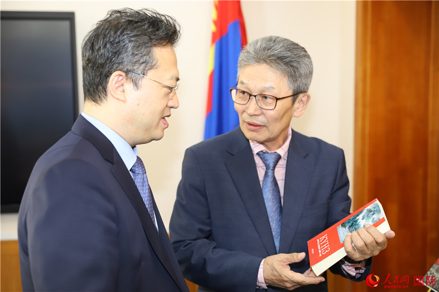 其米德策耶（右一）向李峙介紹翻譯成果。人民網(wǎng)記者 霍文攝