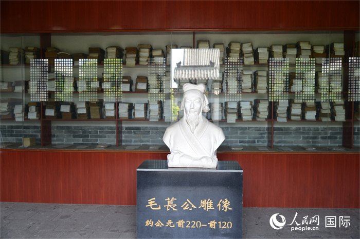 河間詩(shī)經(jīng)齋毛萇雕像。雕像后書櫥中陳列的是歷代各版本《詩(shī)經(jīng)》及譯本。 人民網(wǎng) 趙昭攝