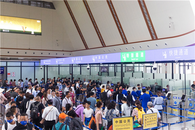 7月22日，乘坐中老鐵路國際旅客列車的旅客在磨憨邊檢大廳排隊候檢。衛(wèi)海林 攝