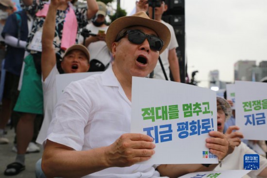 7月22日，在韓國(guó)首爾，人們手舉標(biāo)語(yǔ)參與反戰(zhàn)游行。新華社發(fā)（楊暢 攝）