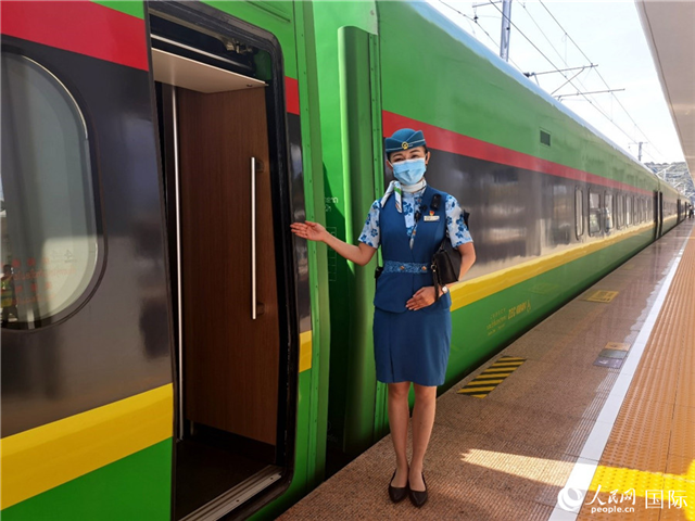 趙瑩靜站在“復(fù)興號”國際旅客列車車廂門口歡迎旅客上車。人民網(wǎng) 杜明明攝