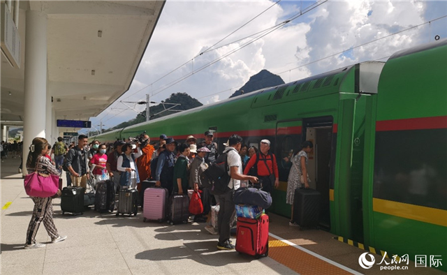 乘坐中老鐵路國際旅客列車的旅客在老撾瑯勃拉邦站排隊(duì)上車。人民網(wǎng)記者 杜明明攝
