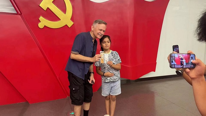 潘維廉和志愿講解員紀念合影。主辦方供圖