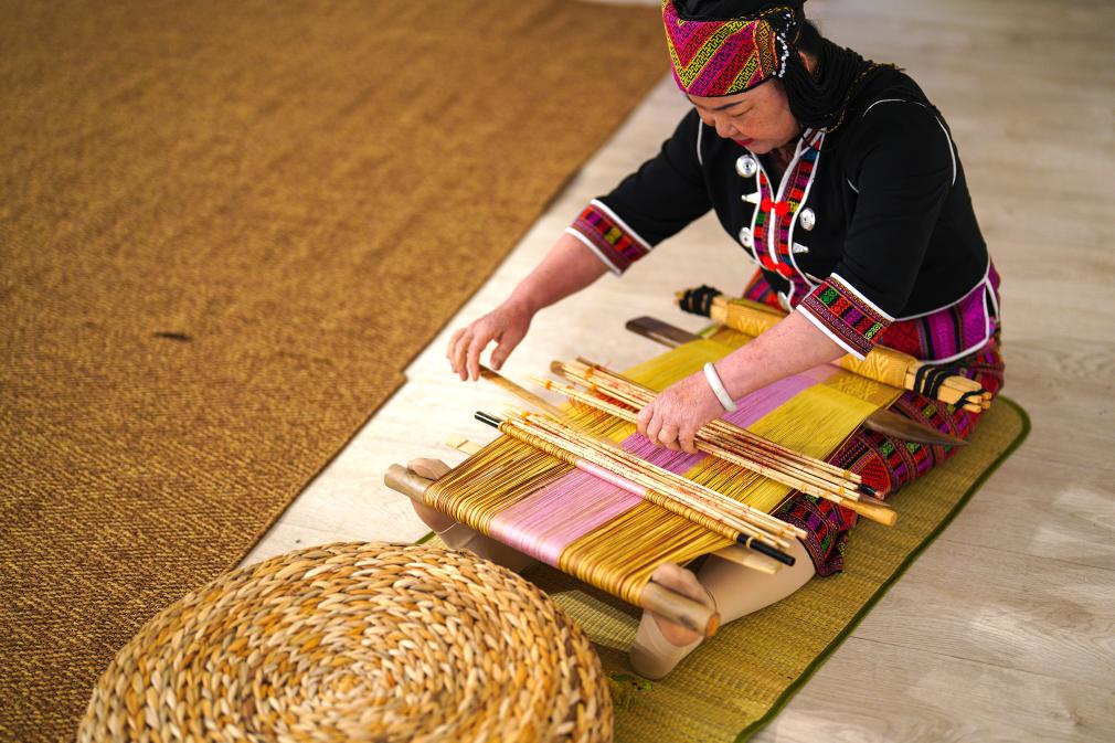 4月17日，黎族傳統(tǒng)紡染織繡技藝國(guó)家級(jí)代表性傳承人劉香蘭在2023年意大利米蘭設(shè)計(jì)周上展示黎錦織造技藝。新華社發(fā)