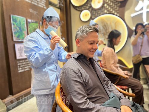   （外媒記者體驗艾灸。中國經(jīng)濟周刊記者 郭志強 攝）