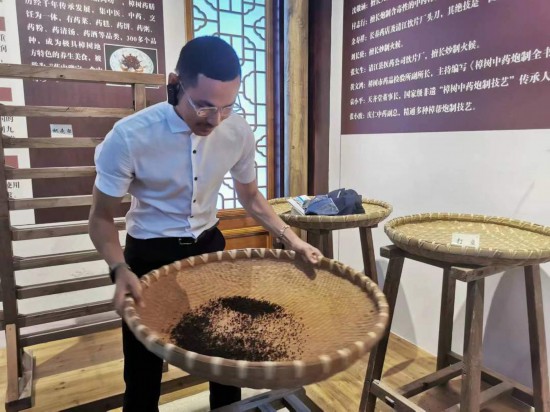 2023“一帶一路”媒體合作論壇聯(lián)合采訪團團員在非遺文化展示館體驗中藥炮制技藝。（本報記者 黃超攝）