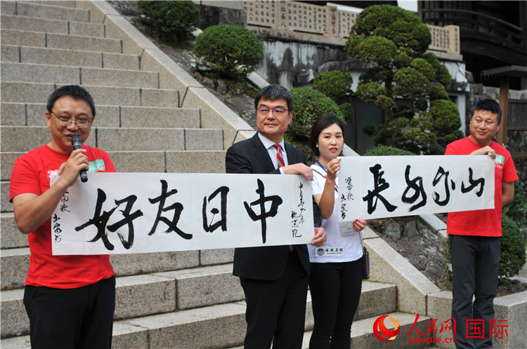 東京中國文化中心主任羅玉泉展示其為本次活動書寫的題詞“中日友好，山高水長”。人民網(wǎng) 蔣曉辰攝