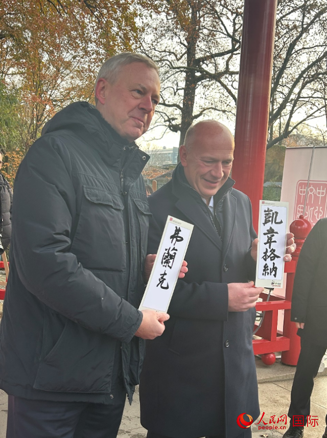 柏林市長(zhǎng)韋格納（右）、動(dòng)物園監(jiān)事會(huì)主席布魯克曼（左）手持中國(guó)文化中心工作人員現(xiàn)場(chǎng)手書(shū)的中文名字。人民網(wǎng)記者 徐馨攝