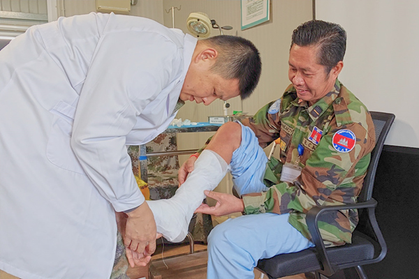 中國第22批赴黎維和醫(yī)療分隊軍醫(yī)為患者打石膏固定患肢。李清竹攝