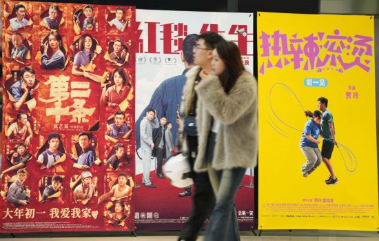 這是2月17日，在沈陽一家影院，觀眾從海報前經(jīng)過。新華社記者李鋼攝