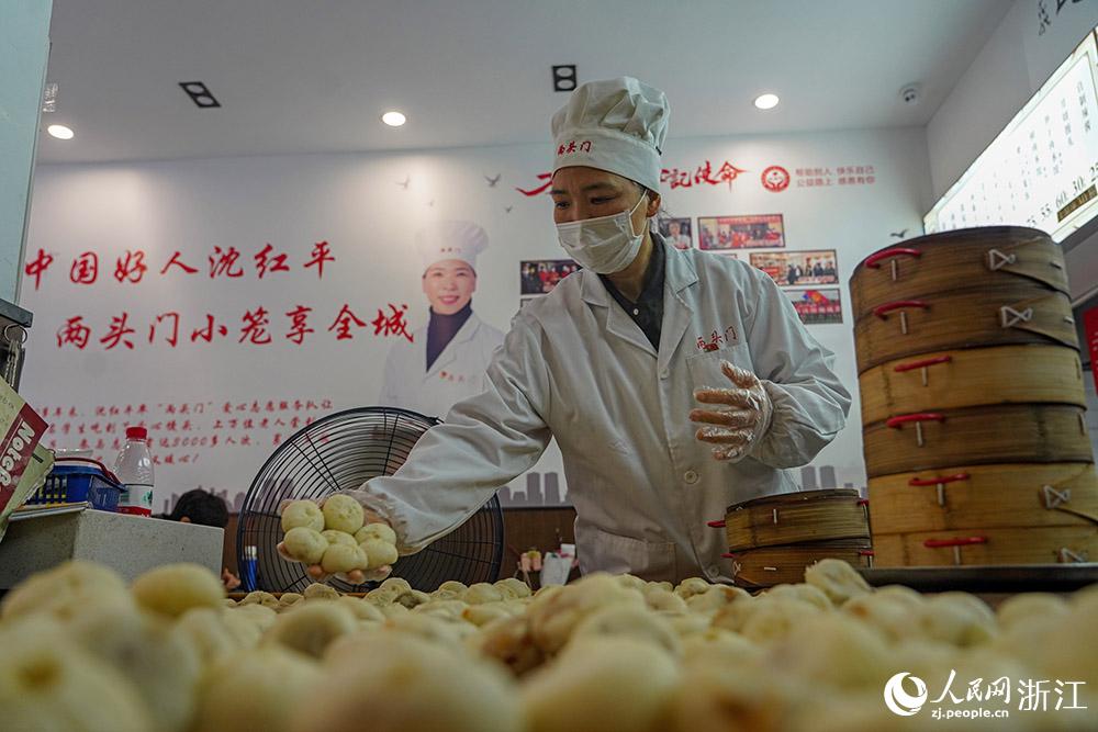 3月31日，在浙江省嵊州市甘霖鎮(zhèn)，嵊州小吃從業(yè)者沈紅平把蒸熟的小籠包晾涼，打包冷藏售賣。人民網(wǎng) 章勇濤攝