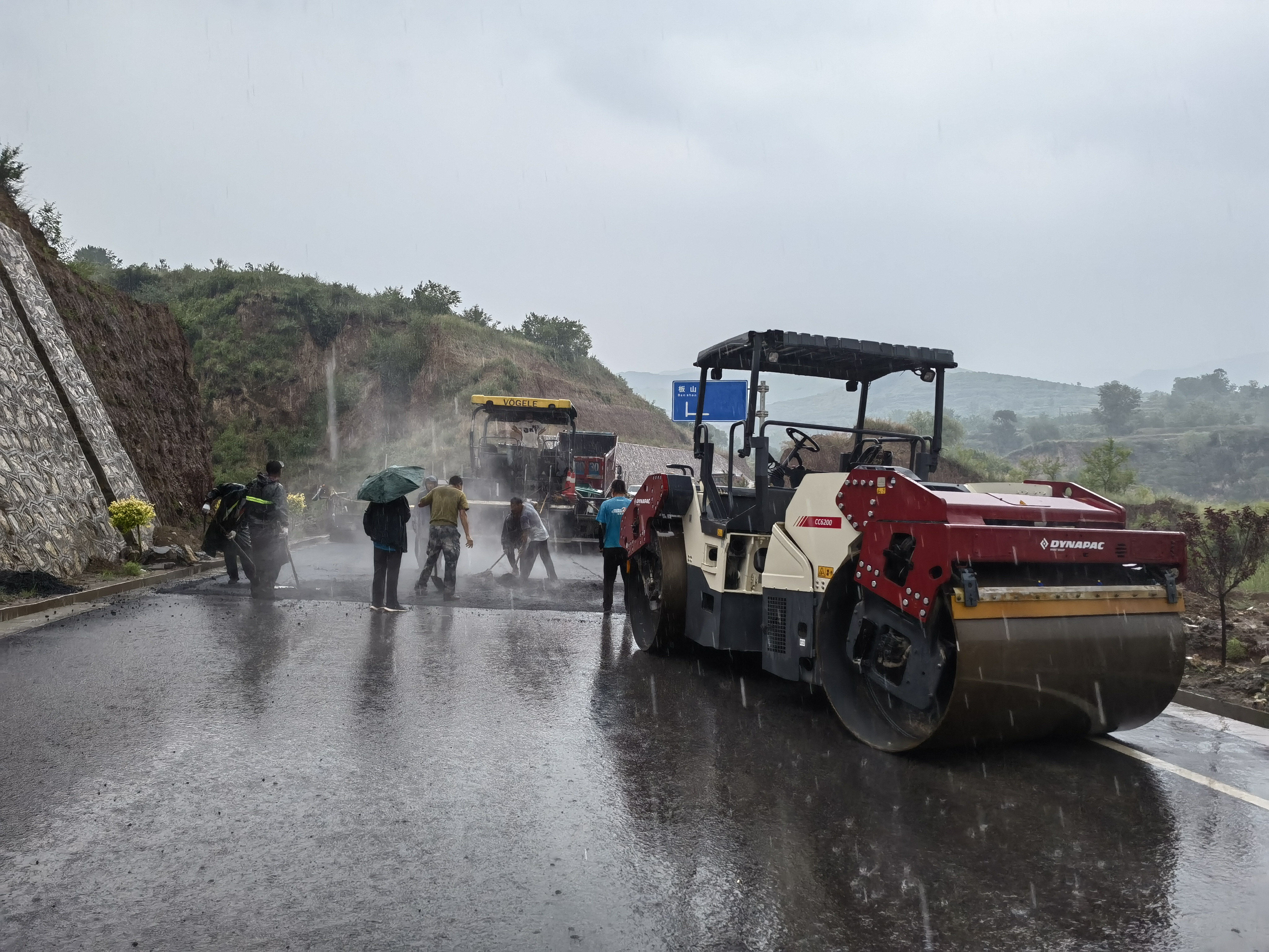路橋工人在大雨中搶修道路。李華英 攝