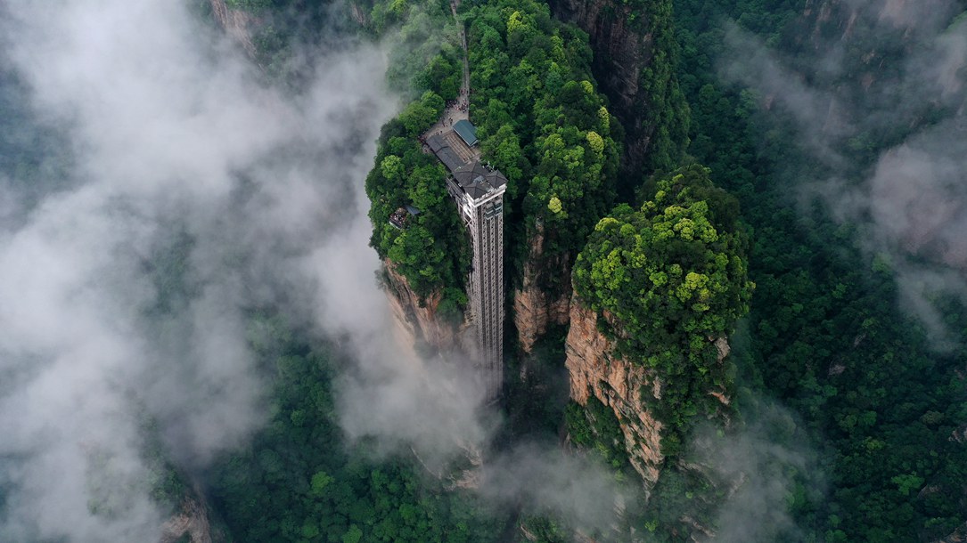 位于張家界武陵源景區(qū)的百龍?zhí)焯蓁偳对谠旗F繚繞的峰林間，雄偉壯觀。吳勇兵攝