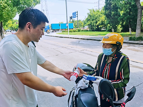 何超為過路的老人送上礦泉水和冷飲。人民網記者 王繼亮攝