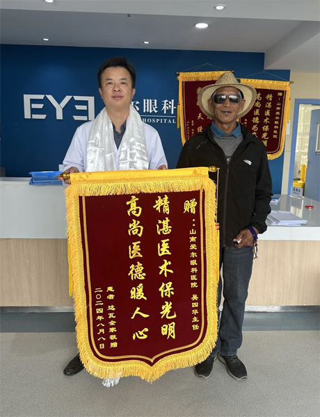 達(dá)瓦老人向吳四華（左）贈(zèng)送錦旗。受訪者供圖