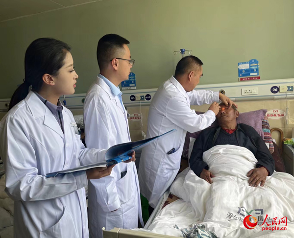 董光明（左三）帶領(lǐng)醫(yī)生對(duì)患者進(jìn)行術(shù)前檢查。人民網(wǎng)記者 杜燕飛攝