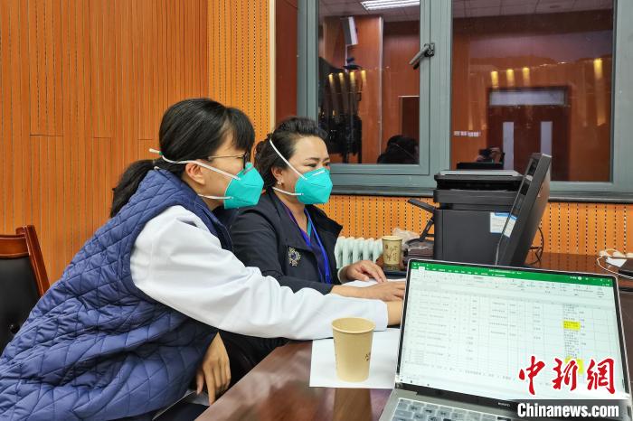 8月9日，楊蘇喬(左)在拉薩方艙醫(yī)院指揮部讀取艙內(nèi)患者胸部CT?！∈茉L者供圖