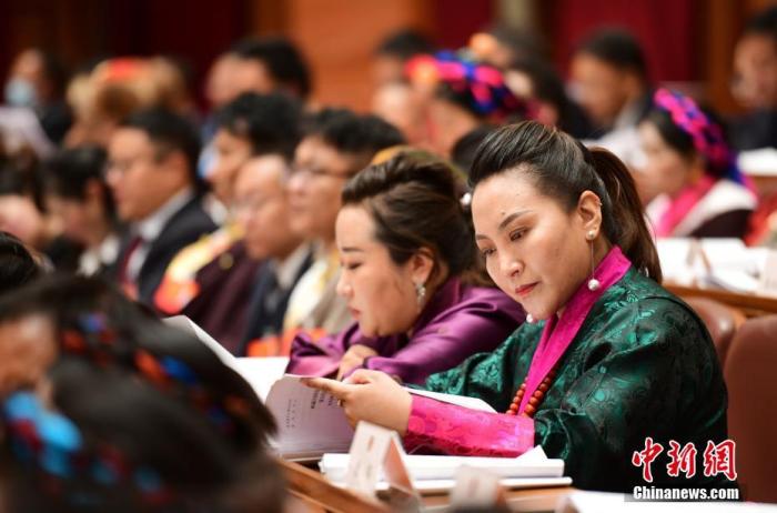 1月5日，次旦卓嘎(右一)在拉薩參加西藏自治區(qū)第十一屆人民代表大會第五次會議第二次全體會議。西藏自治區(qū)人大代表次旦卓嘎來自日喀則市定日縣，定日縣被稱為“洛諧故鄉(xiāng)”，作為西藏民間歌舞，洛諧已被列入中國國家非物質(zhì)文化遺產(chǎn)項目名錄，這是集歌、舞、樂、彈唱于一體的綜合藝術(shù)形式。參加完西藏2022年新年音樂會的次旦卓嘎告訴記者，每年參加的基層演出可達80場，“我希望用最純粹的方式，把最好的聲音帶到西藏乃至中國的各個角落?！?<a target='_blank' href='/'><p  align=