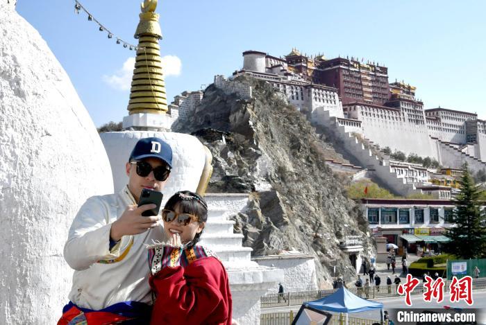 4月17日，游客身著藏式元素服裝在拉薩布達拉宮觀景臺拍照留念?！±盍?攝