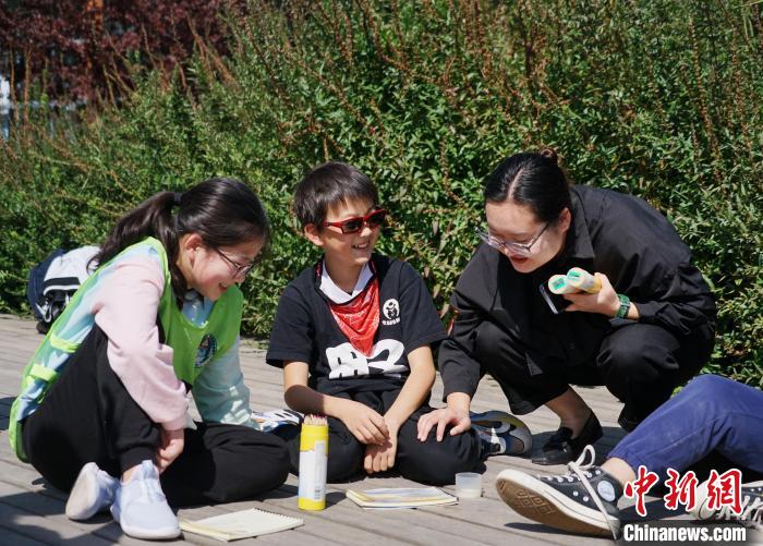 圖為小朋友在青海西寧湟水國家濕地公園內(nèi)認識植物并進行繪畫?！●R銘言 攝