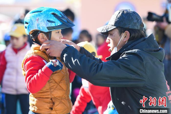 圖為拉薩市實驗幼兒園孩子在教練的幫助下穿戴頭盔?！『闻罾?攝