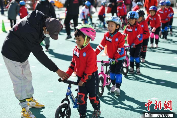 圖為拉薩市實驗幼兒園孩子們在教練的指導(dǎo)下練習(xí)滑步車。　何蓬磊 攝