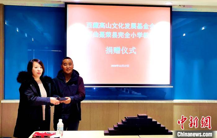 圖為西藏高山文化發(fā)展基金會理事長溫麗向聶榮縣完全小學(xué)負(fù)責(zé)人捐助儀器?！∮谫e 攝