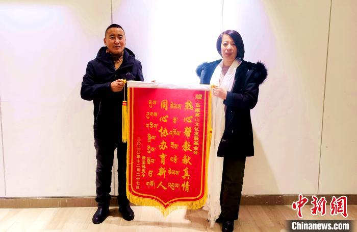 圖為聶榮縣完全小學(xué)向西藏高山文化發(fā)展基金會贈送錦旗?！∮谫e 攝