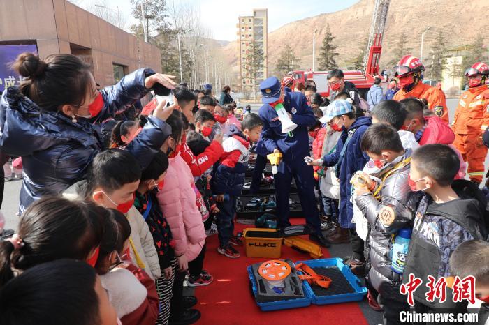 圖為小朋友們聽消防員講解消防器材?！铨埥?攝