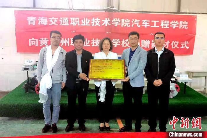 圖為李富香(中)代表學(xué)校為州縣技校捐贈器材。(資料圖) 青海省教育廳供圖