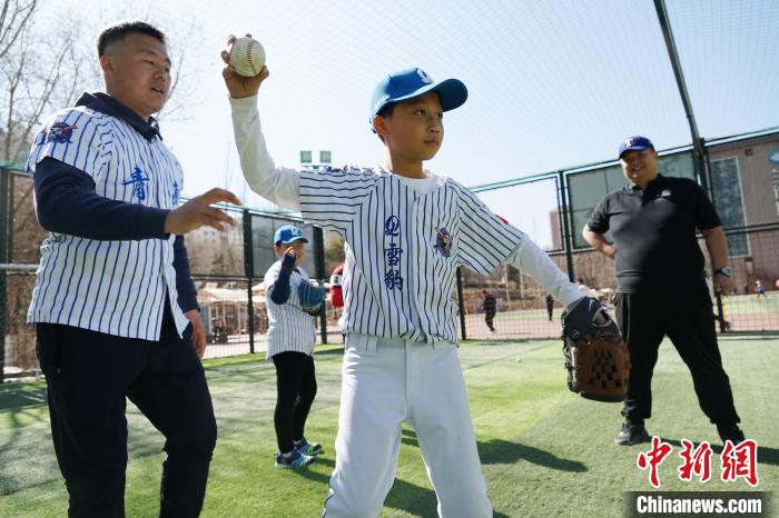 圖為教練指導(dǎo)小棒球手?jǐn)S球技術(shù)?！●R銘言 攝