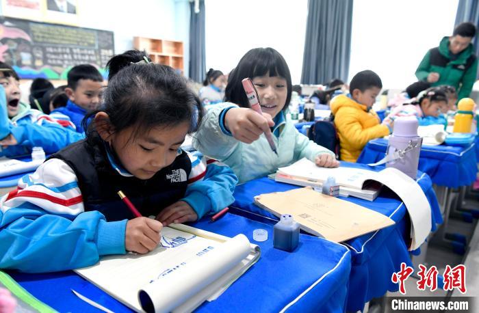 3月14日，西藏拉薩市第一小學(xué)一年級(jí)六班學(xué)生白瑪朗珍(圖左)在藏語(yǔ)文課上書寫藏文?！±盍?攝