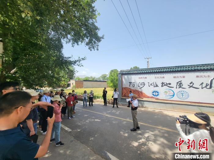 圖為中國地質(zhì)大學(xué)(北京)教授張緒教介紹村落情況?！『衍?攝