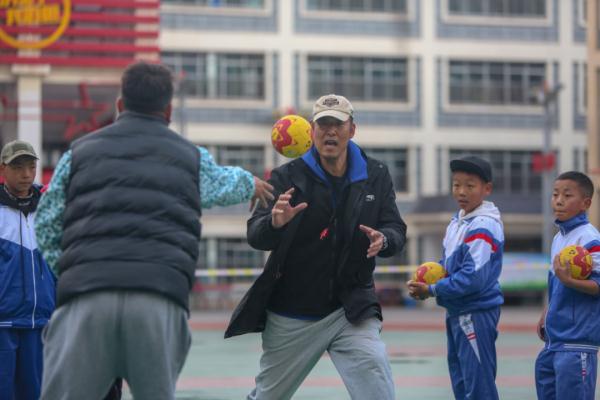 在高原上教孩子們打手球，“慢慢兒來，甭著急！”