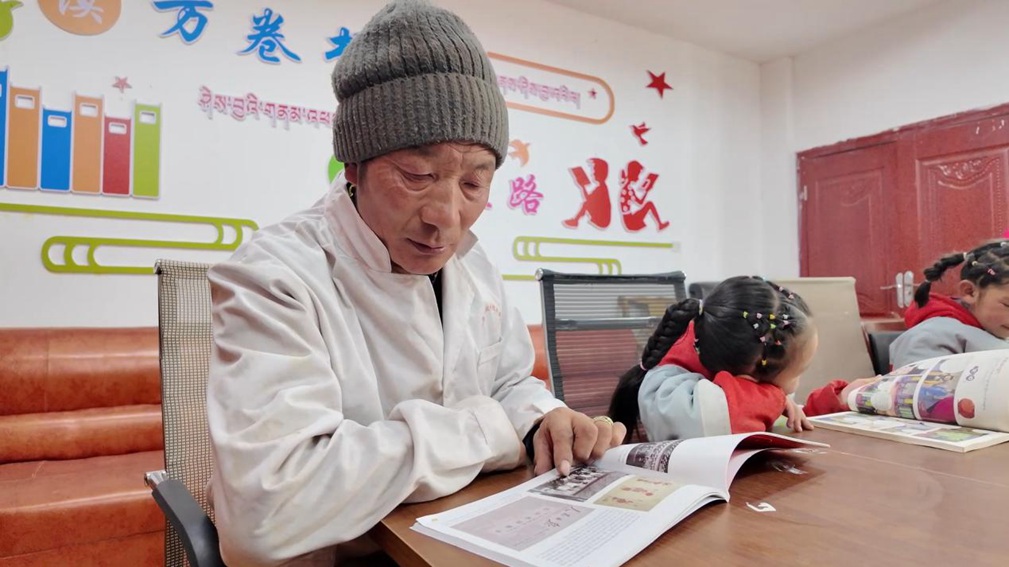 一位當(dāng)?shù)卮迕窈秃⒆觽冊谀良視堇锉M情享受閱讀時光。申扎縣融媒體中心供圖