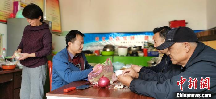 圖為扶貧路上“臨時(shí)一家人”準(zhǔn)備午餐?！∥航ㄜ?攝