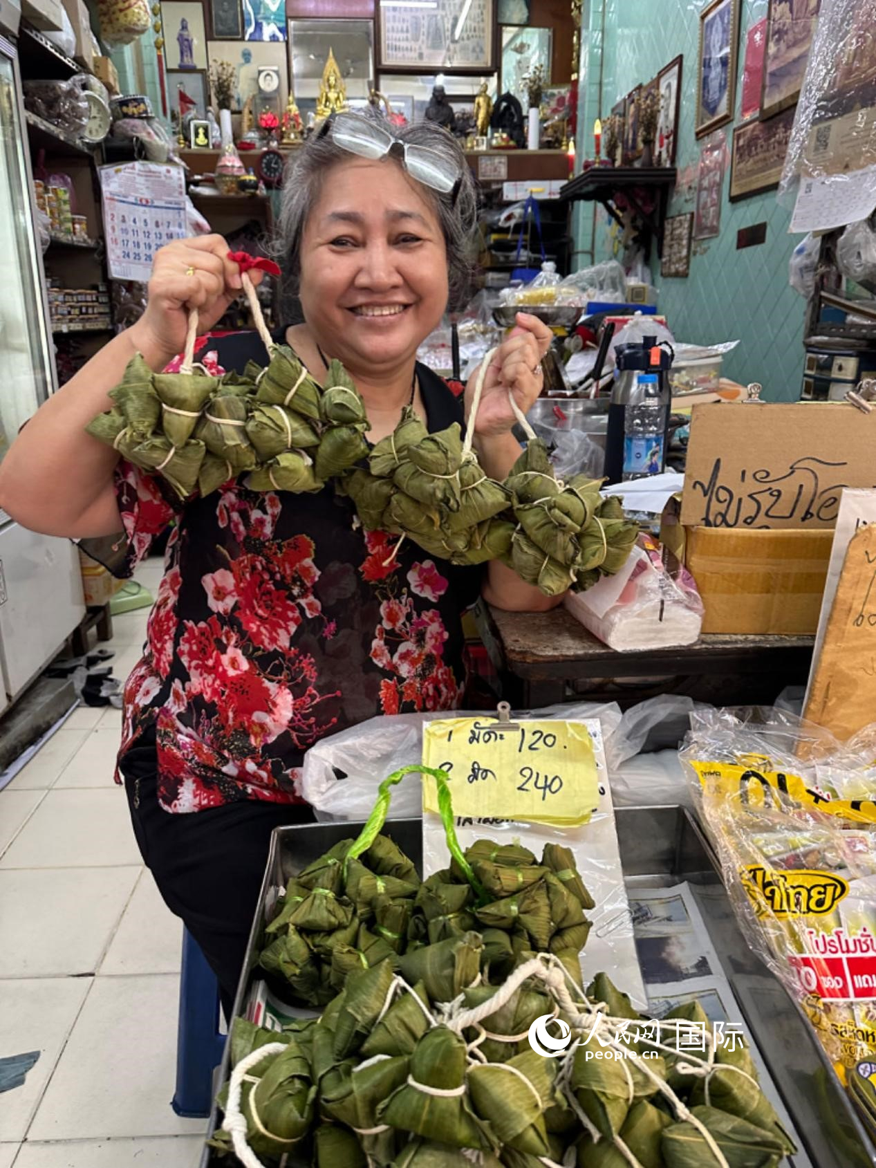商家向顧客介紹“吉掌”（粽子的一種，一串一串，個頭較小）。人民網(wǎng)記者 簡承淵攝