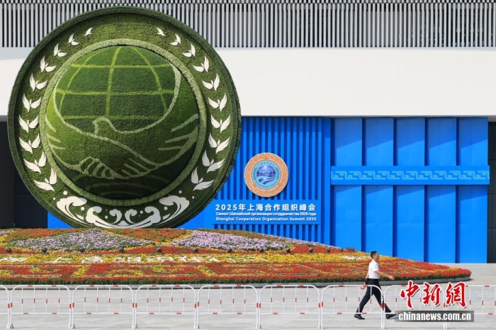 8月31日，天津，一名工作人員從2025年上海合作組織峰會(huì)主會(huì)場(chǎng)外的景觀花壇旁經(jīng)過。當(dāng)日，2025年上海合作組織峰會(huì)在天津舉行。<a target='_blank' href='/'><p  align=
