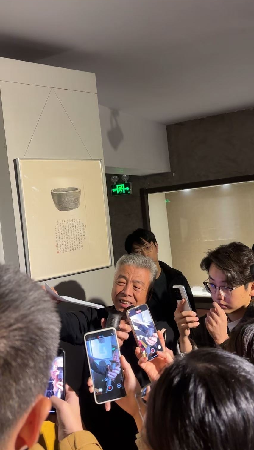 黑陶邢文化博物館館長邢葆東展示兩張相疊的A4紙，向記者解釋此為杯口的厚度。